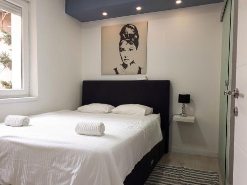 Zagreb Creative Apartments APP 1 في زغرب: غرفة نوم بسرير كبير مع شراشف بيضاء