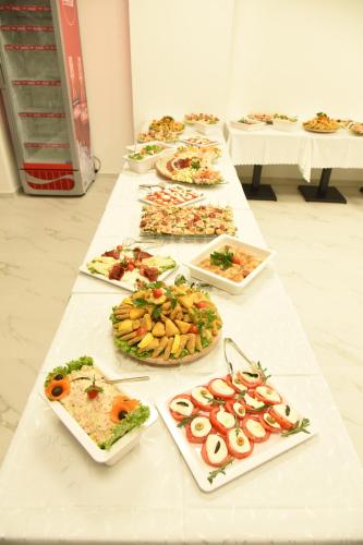 a long table with many plates of food on it at Hotel DOA in Skopje