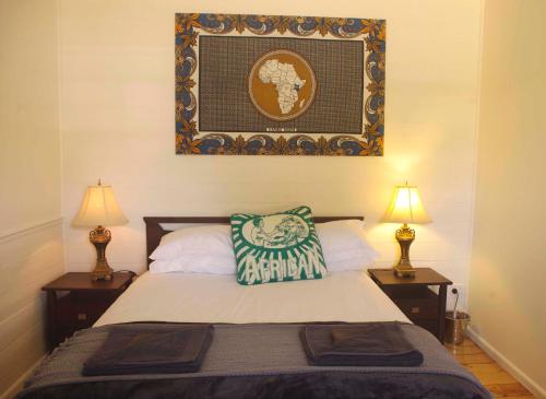 um quarto com uma cama com dois candeeiros e uma imagem na parede em Darcy's Cottage on Piper em Kyneton