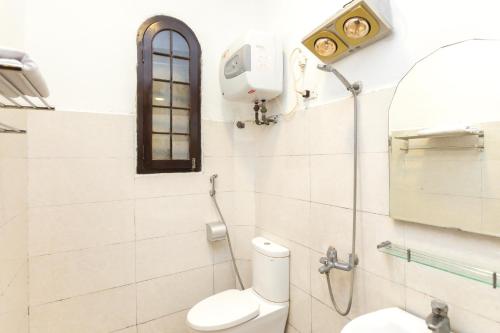 a bathroom with a shower and a toilet and a mirror at OYO 619 Chikoo Homestay spot-on in Hanoi