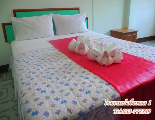 a bed with three pairs of shoes on it at Nam Pueng Place 1 in Chiang Saen