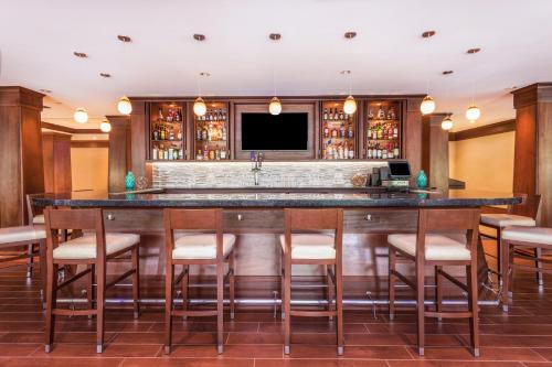 a large bar in a hotel room with stools at Holiday Inn Charlottesville-Monticello by IHG in Charlottesville