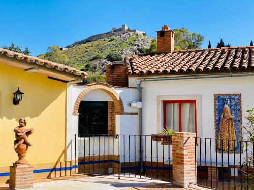 una casa con una valla y una montaña en el fondo en La Estancia Villa Rosillo, en Aracena