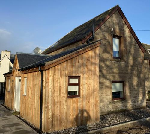 a wooden building with windows on the side of it at The Smiddy House in Auchterarder
