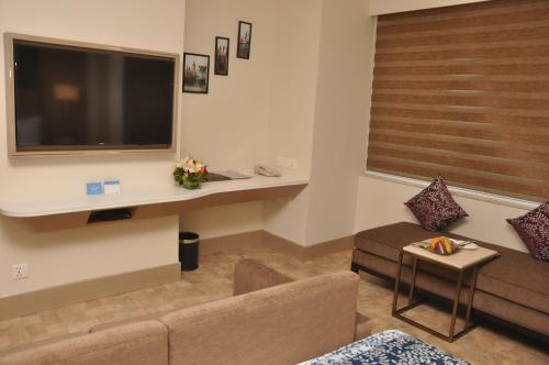 a living room with a couch and a large television at Days Hotel Jaipur Tonk Road By Wyndham in Jaipur