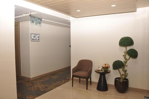 a waiting room with a chair and plants at Days Hotel Jaipur Tonk Road By Wyndham in Jaipur