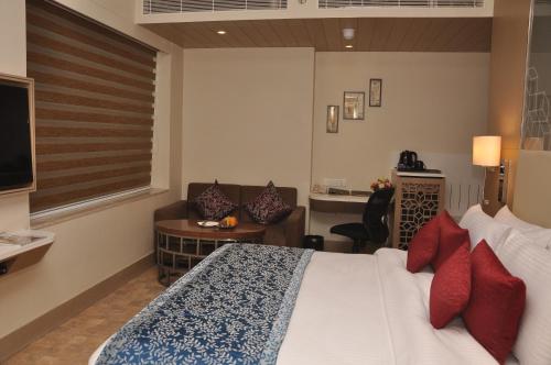 a hotel room with a bed and a living room at Days Hotel Jaipur Tonk Road By Wyndham in Jaipur
