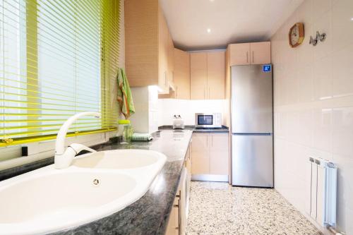a kitchen with a sink and a refrigerator at Apartamento Gold Sierra Nevada in Granada