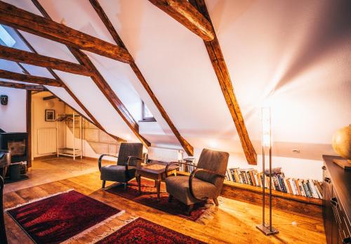 Pokój z krzesłami, stołem i książkami w obiekcie Designer Loft w Czeskim Krumlovie