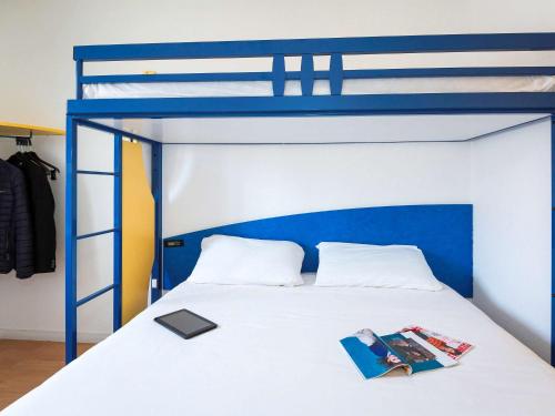 - une chambre avec des lits superposés bleus et un livre dans l'établissement ibis budget Béziers Centre Palais Congres, à Béziers