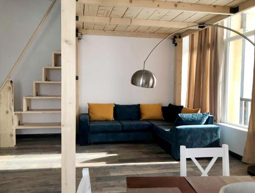 ein Wohnzimmer mit einem blauen Sofa und einer Treppe in der Unterkunft Gudauri Studio in Gudauri