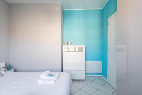 a room with two beds and a blue wall at Lido Apartments by Quokka 360 - 5 min from the centre and the Lugano Lido in Lugano