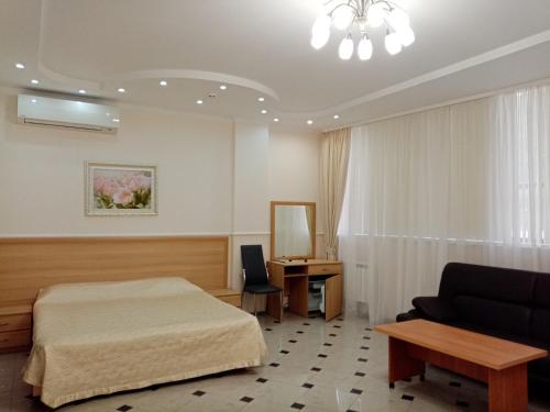 ソチにあるSokol Hotelのベッドルーム1室(ベッド1台、ソファ、デスク付)