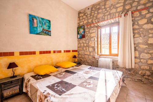 Un dormitorio con una cama con almohadas amarillas. en Gîtes du Domaine de Serre Long, en Saint-Maurice-dʼIbie