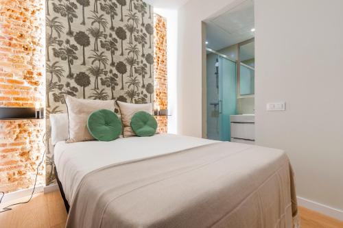 - une chambre avec un grand lit et 2 oreillers verts dans l'établissement Apartamentos con encanto en La Latina, à Madrid