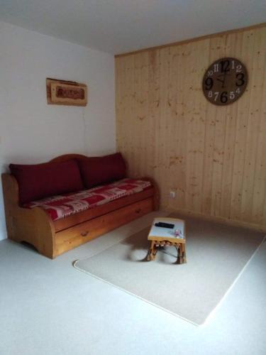 - un salon avec un canapé et un petit tabouret dans l'établissement Locations de la cascade 6 personnes, à Besse-et-Saint-Anastaise