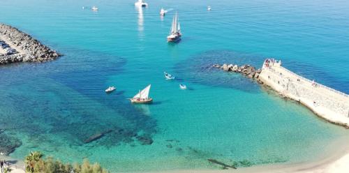 a group of boats in the water near a beach at Il Casalino Apartment in Pizzo