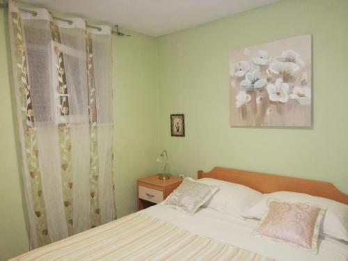een slaapkamer met een bed en een foto van bloemen bij I&J Relaxing Beach Apartments in Račišće