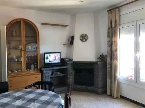 a living room with a fireplace and a television at Apartamento familiar con Wifi in Navás