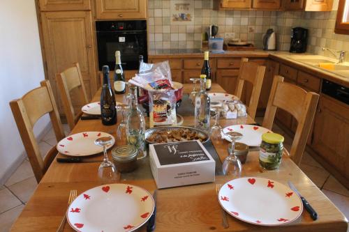 a kitchen table with plates and bottles of wine at La Ferme de Sous-Lachat in Samoëns