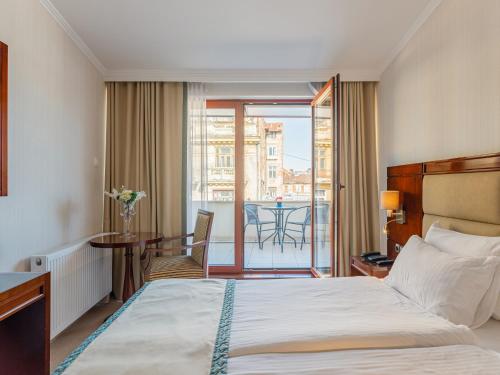 a hotel room with a bed and a balcony at Concorde Old Bucharest Hotel in Bucharest