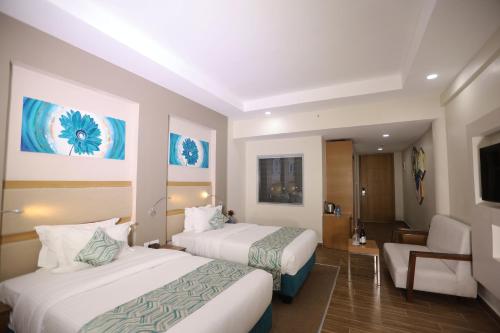 a hotel room with two beds and a chair at PrideInn Plaza Nairobi Airport in Nairobi