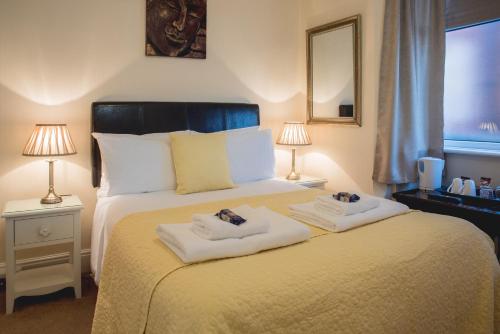 a bedroom with a bed with two towels on it at Arlana Guest House in Cleethorpes