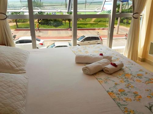 a bed with towels on it with a view of the ocean at Flat Tambaú Solar do Atlântico in João Pessoa