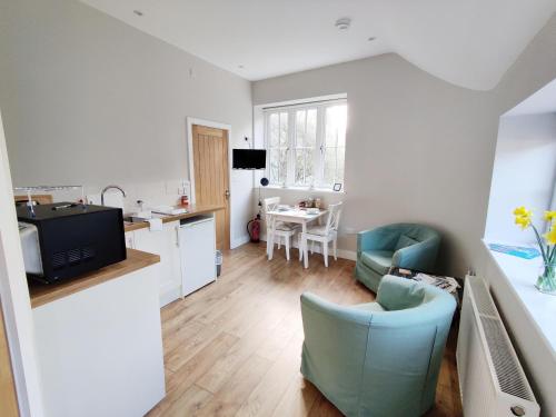 a kitchen and living room with a couch and a table at Rose Barn in West Lavington