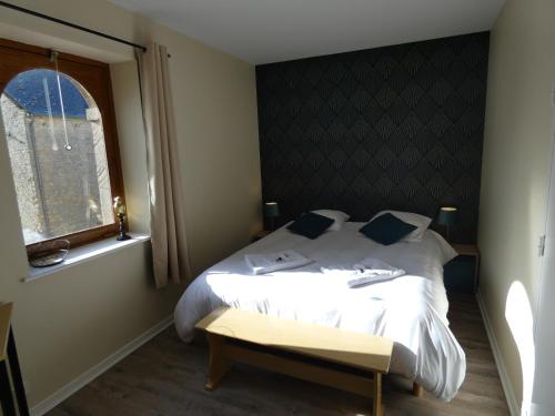 a bedroom with a white bed and a window at Hôtel Restaurant le clos de l 'Ancien Pressoir in Commes