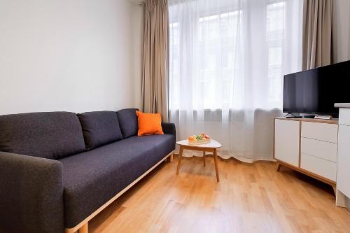a living room with a couch and a tv at Residential Barona Apartments in Riga Centre in Rīga