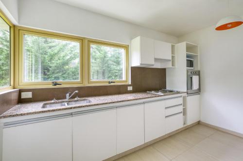a kitchen with white cabinets and a window at Albar Club de Mar in Pinamar