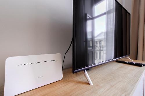 a flat screen tv sitting on top of a table at Residential Barona Apartments in Riga Centre in Rīga