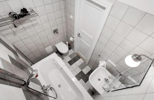 a bathroom with a tub and a toilet and a sink at Residential Barona Apartments in Riga Centre in Rīga
