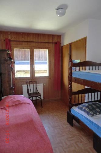 een slaapkamer met 2 stapelbedden en een raam bij Les Passereaux 2 in Saint-Gervais-les-Bains