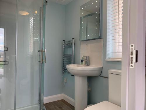 a bathroom with a sink and a shower at Hebridean Holiday Cabins in Breasclete