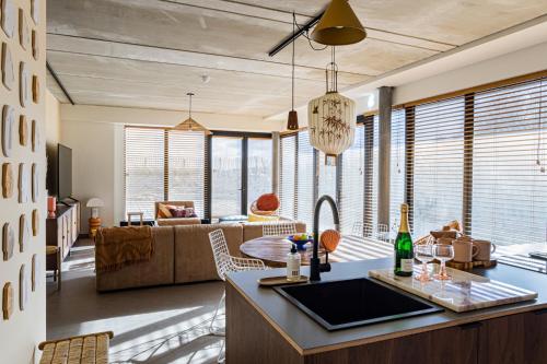 a kitchen and living room with a couch and a table at Strandhotel Zoomers in Castricum