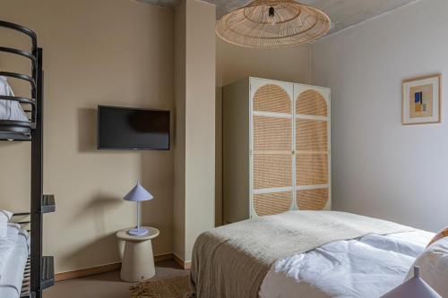 a bedroom with a bed and a tv on the wall at Strandhotel Zoomers in Castricum