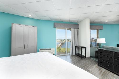 a bedroom with a white bed and a blue wall at Holiday Inn Charleston-Riverview by IHG in Charleston