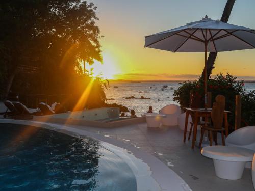 a sunset over the ocean and a swimming pool at Hotel Portaló in Morro de São Paulo