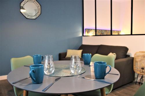 a dining room with a table with blue cups and chairs at Pontivy Centre, Studio Confort in Pontivy