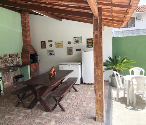 a kitchen with a wooden table and a table and chairs at Pousada Rancho Verde in Porto Seguro