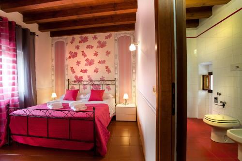 una camera con letto rosso e un bagno di Apartments City Center a Verona