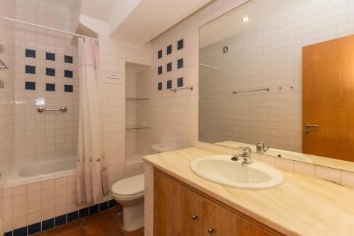 un bagno con lavandino, WC e specchio di Villa Blue Garden by ALGARVEMANTA a Manta Rota