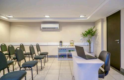 uma sala de conferências com cadeiras e um computador portátil no balcão em Apartamento Natal em Natal