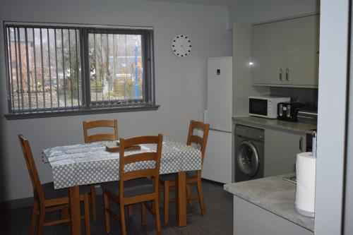 a kitchen with a table and chairs in a kitchen at Dunroamin Self-Catering Apartment in Aviemore