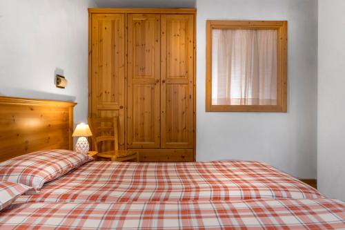 a bedroom with a bed and a dresser at Chalet Stelle Di Neve in Bormio