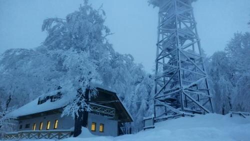 a building covered in snow next to a bridge at Nauportus in Vrhnika