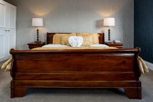 a bedroom with a large wooden bed with two lamps at The Clarendon Hotel in London