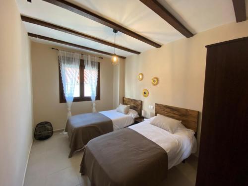 1 dormitorio con 2 camas y ventana en Alojamiento Rural El Refugio, en Genalguacil